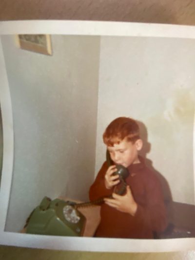 A boy on a green rotary telephone, 1971.
