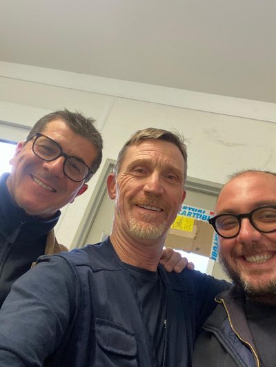 Three men in a workshop doorway.