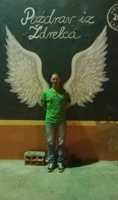 Standing in front of a mural of angel wings.